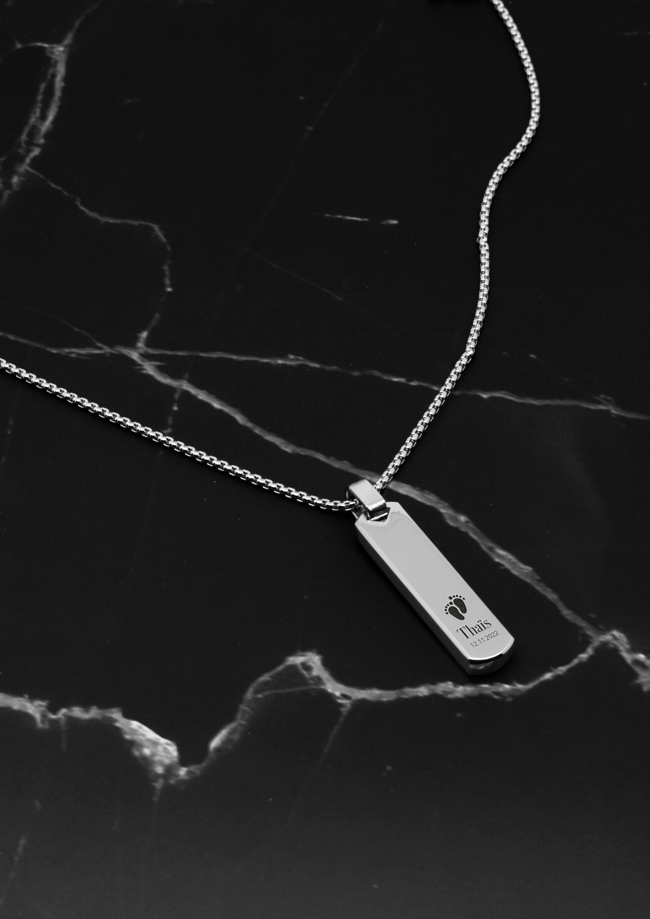 collier de naissance pour homme avec prénom argenté et petits pieds